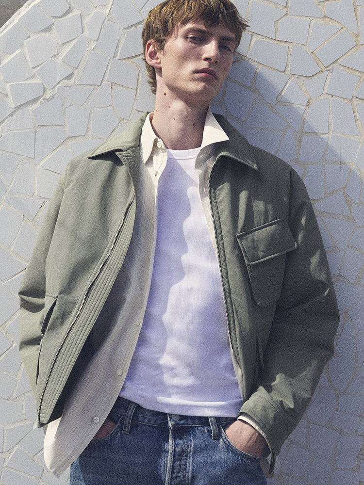 man wearing turtleneck standing on balcony